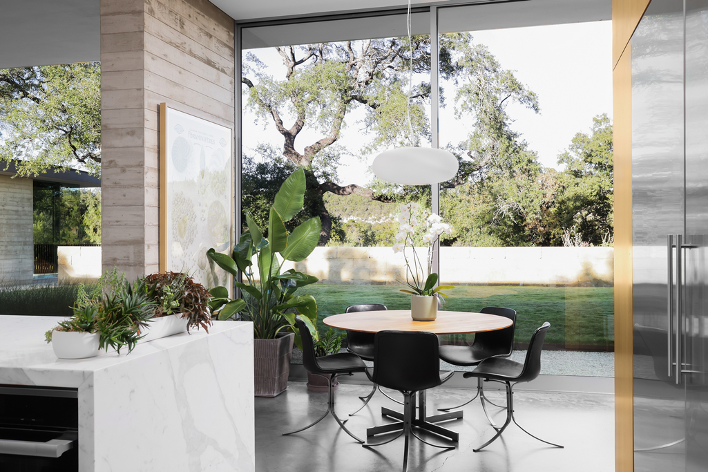 Modern Breakfast Room And Kitchen With Walls Of Glass Looking Onto Grass And Live Oaks