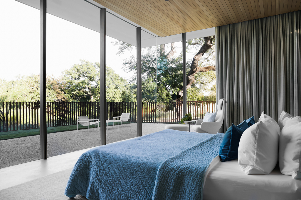 Modern Bedroom With Large Bed Facing Wall Of Floor To Ceiling Windows